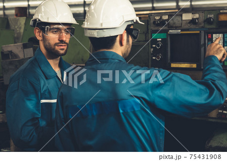 Group of skillful factory workers using machine equipment in workshop Group of skillful factory workers using machine equipment in workshop 75431908