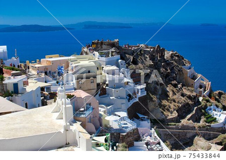 サントリーニ島のイアの夕日スポットに集まる人々の写真素材