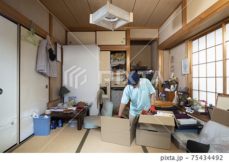 散らかった部屋の整理をする男性作業員 75434492