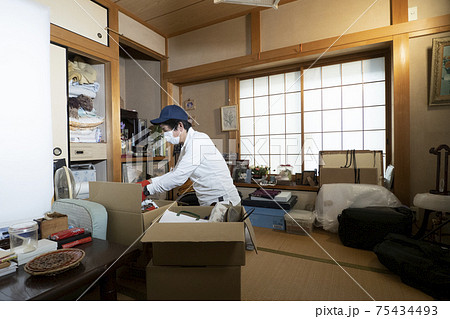 散らかった部屋の整理をするミドル男性作業員 散らかった部屋の整理をするミドル男性作業員 75434493