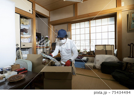 散らかった部屋の整理をするミドル男性作業員 75434494