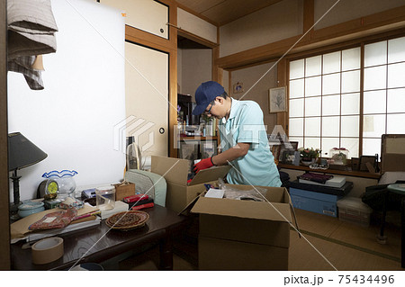 散らかった部屋の整理をする男性作業員 75434496