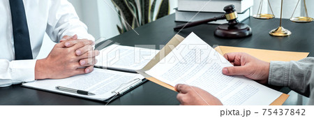 Male lawyer discussing negotiation legal case with client meeting with document contact in courtroom, law and justice concept 75437842