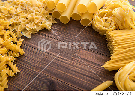 Different kinds of pasta on a wooden background. Different kinds of pasta on a wooden background. 75438274