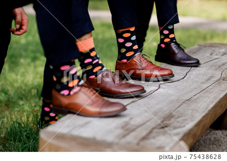 Fashion men footwear. guys wearing leather shoes and colorful socks on wooden bench. selective focus. Fashion men footwear. guys wearing leather shoes and colorful socks on wooden bench. selective focus. 75438628