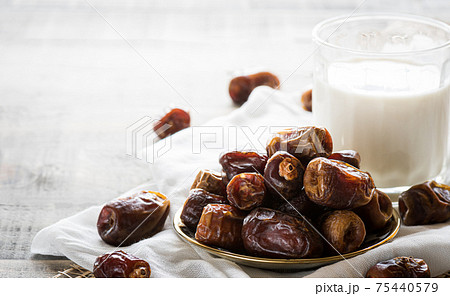 Milk and dates fruit on dark wooden background. Muslim simple Iftar concept. Ramadan food and drinks. Milk and dates fruit on dark wooden background. Muslim simple Iftar concept. Ramadan food and drinks. 75440579