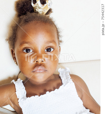 little cute african american girl playing at home, pretty adorable princess in interior happy smiling, lifestyle people concept 75442317