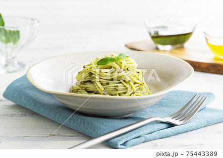 ナチュラルな背景で撮影された、バジルソースのスパゲティー ナチュラルな背景で撮影された、バジルソースのスパゲティー 75443389