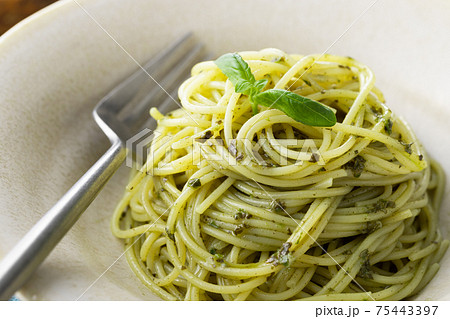 ナチュラルな背景で撮影された、バジルソースのスパゲティー ナチュラルな背景で撮影された、バジルソースのスパゲティー 75443397