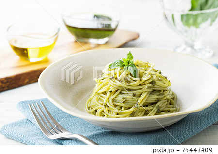 ナチュラルな背景で撮影された、バジルソースのスパゲティー 75443409