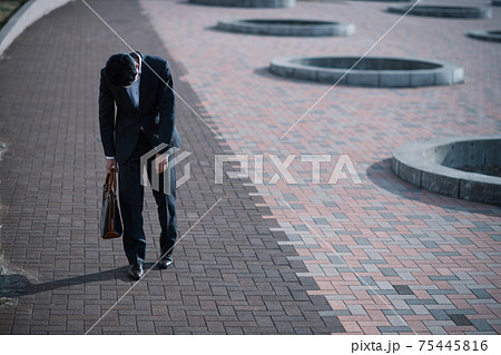 落ち込んで歩く男性・悩むスーツの男性 75445816