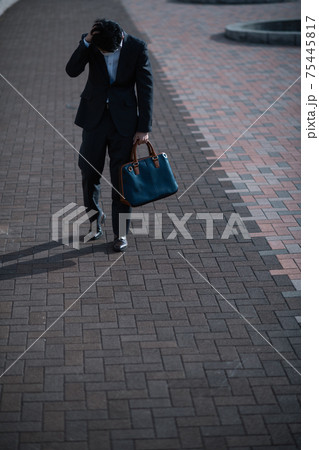 落ち込んで歩く男性・悩むスーツの男性 75445817