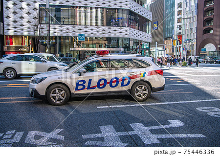 日本の東京都市景観　銀座四丁目の交差点を通過する血液供給車 75446336