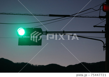 夕暮れの青信号になった信号機 75447721