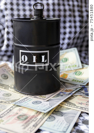 Barrel of oil on a background, american dollars and arabian background. Word on barrel is Oil. Falling trend of barrel price decrease of earning and global economics . Selective focus. Barrel of oil on a background, american dollars and arabian background. Word on barrel is Oil. Falling trend of barrel price decrease of earning and global economics . Selective focus. 75451880