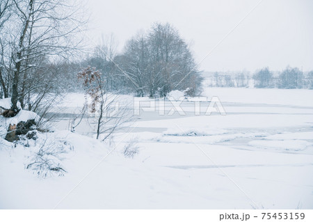 Winter frosty landscape of the river with broken ice 75453159