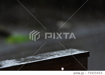 大雨の日ウッドデッキ手摺にたまった雨と波紋 75455453