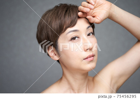 額に手を当てる中年の日本人女性 75456295