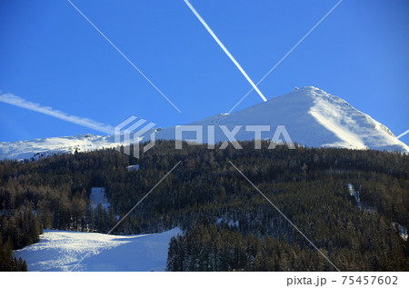snow ski and forest, snowcapped. contrail in Austria 75457602