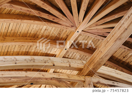 Part of the wooden architecture of the building interior. The wood-paneled ceiling with wooden beams lining. Everywhere is present texture of wood with knots and its own specific structure. Part of the wooden architecture of the building interior. The wood-paneled ceiling with wooden beams lining. Everywhere is present texture of wood with knots and its own specific structure. 75457823
