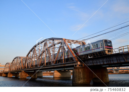 夕日を浴びた荒川橋梁を渡る京成電鉄3000形電車 75460832