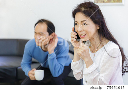 電話をする女性と聞き耳を立てる男性 75461015