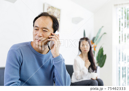 電話をする男性と会話が気になる女性 75462333