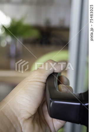 Woman hand holding the door bar to open the door Woman hand holding the door bar to open the door 75463025