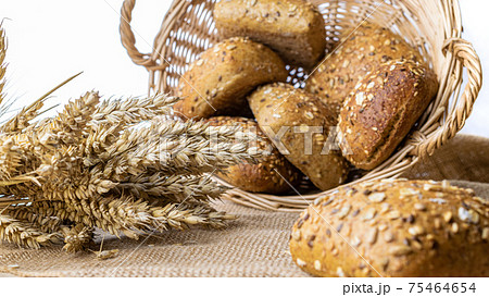 Freshly baked bread. Fresh loaf of rustic traditional bread with wheat grain ear or spike plant on linen texture background. Rye bakery with crusty loaves and crumbs. Healthy Food concept. Freshly baked bread. Fresh loaf of rustic traditional bread with wheat grain ear or spike plant on linen texture background. Rye bakery with crusty loaves and crumbs. Healthy Food concept. 75464654