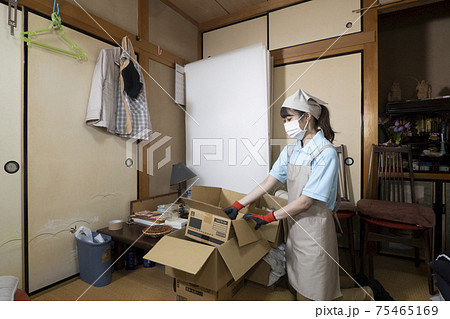 散らかった部屋を片付ける女性作業員 散らかった部屋を片付ける女性作業員 75465169