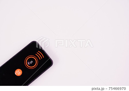 Black remote control for the camera on a white background.  75466970