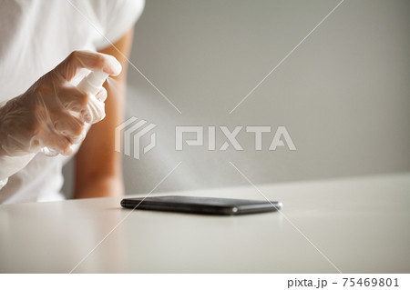 Close up woman disinfecting phone with antiseptic 75469801