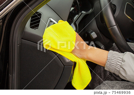 Hand with yellow microfiber cloth polishing car 75469936