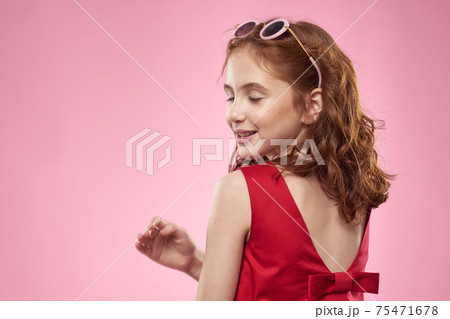 Cheerful little girl childhood dark glasses red dress lifestyle pink background 75471678