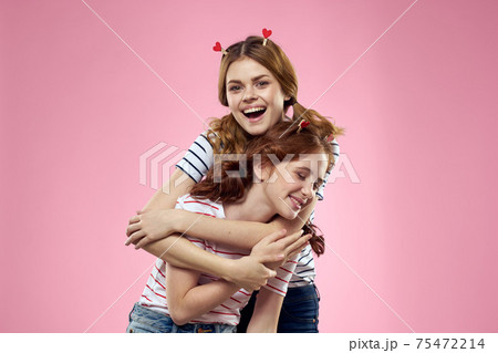 Woman and little girl on a pink background fun sisters friends family 75472214