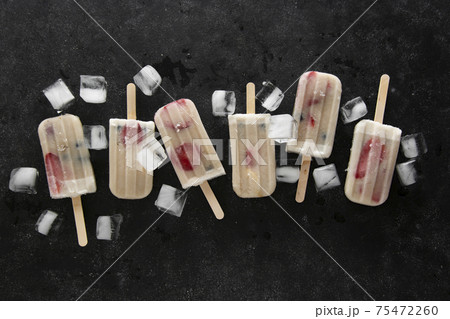 Homemade lolly ice cream with strawberries, blueberries and bananas. Black background. Homemade lolly ice cream with strawberries, blueberries and bananas. Black background. 75472260