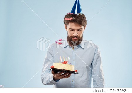 cake in a plate and birthday man with a cap on his head blue backgroun cake in a plate and birthday man with a cap on his head blue backgroun 75472924
