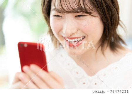 スマートフォンを見る若い女性 スマートフォンを見る若い女性 75474231