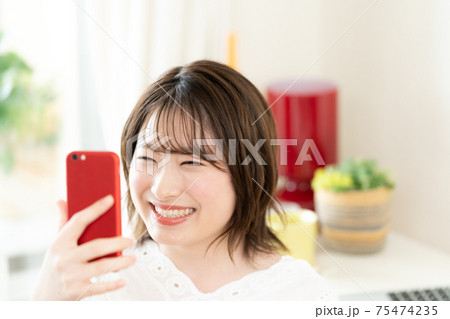 スマートフォンを見る若い女性 スマートフォンを見る若い女性 75474235