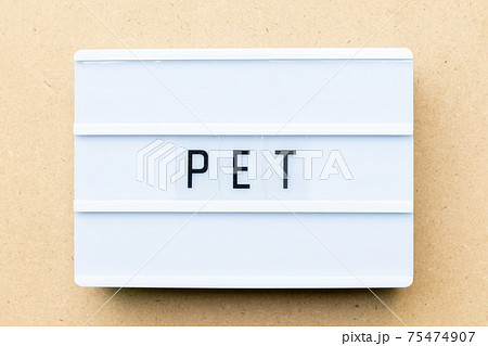 White lightbox with word PET (animal or abbreviation of polyethylene terephthalate) on wood background 75474907