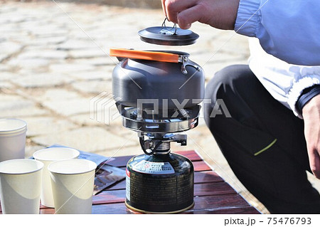 ガスボンベにやかんをかけてお湯を沸かしている 75476793