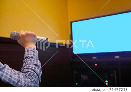 カラオケでマイクを持って唄うイメージ。 カラオケでマイクを持って唄うイメージ。 75477233