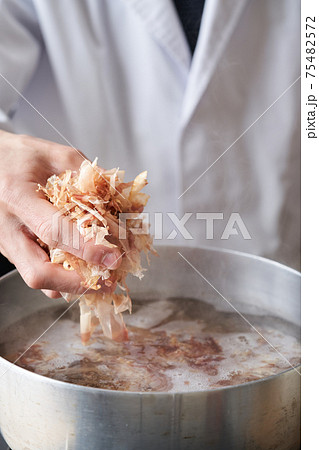 鰹節を鍋に入れる板前 75482572