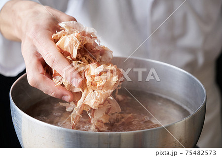 鰹節を鍋に入れる板前 75482573