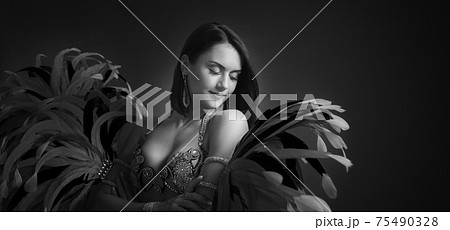 Beautiful woman in carnival costume with feathers and rhinestones. Beautiful woman in carnival costume with feathers and rhinestones. 75490328