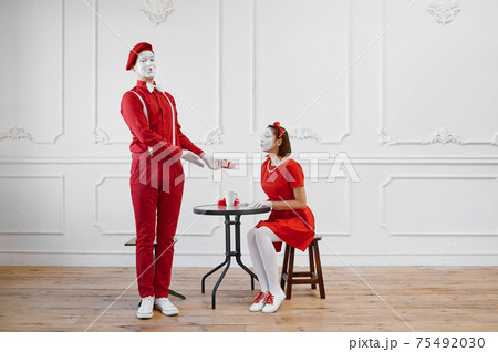 Two mime artists in red costumes, scene with gift 75492030