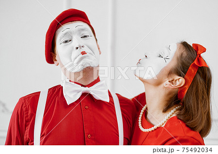 Two mime artists in red costumes, kissing scene 75492034