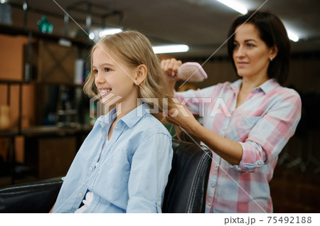 Mother and daughter do their hair in salon 75492188
