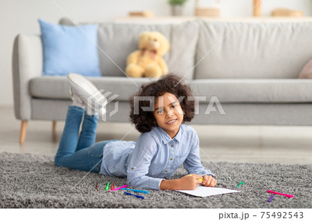 African American girl drawing on paper with colorful crayons 75492543