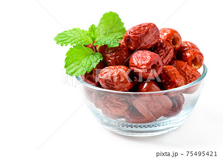 Dried Jujube, Chinese dried red date fruit with Mint leaves in glass cup isolated on white,herbal fruits. Dried Jujube, Chinese dried red date fruit with Mint leaves in glass cup isolated on white,herbal fruits. 75495421